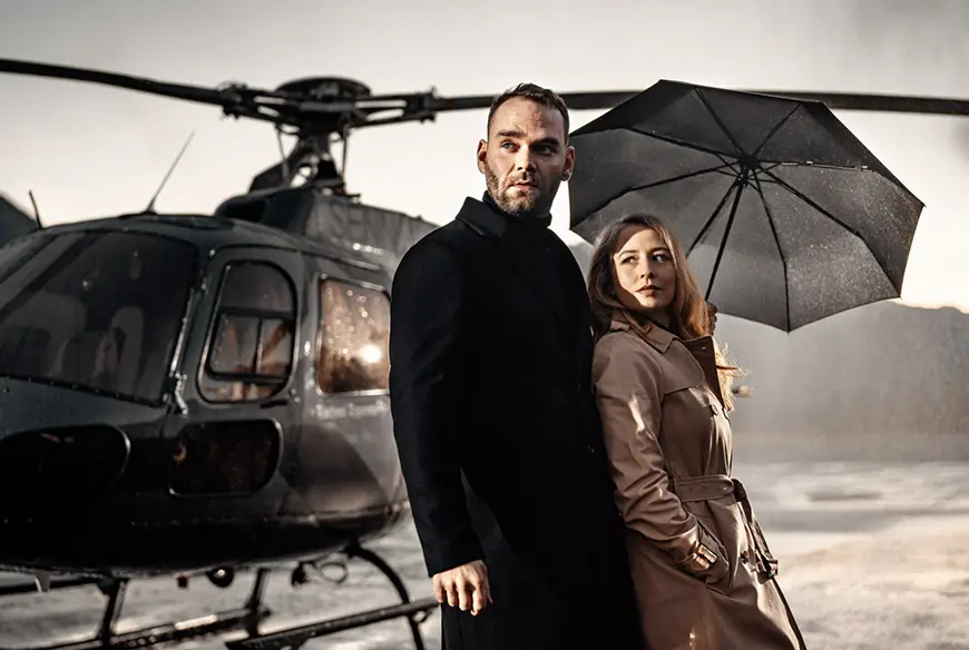 Para trzymająca parasol Doppler Superstrong na tle helikoptera